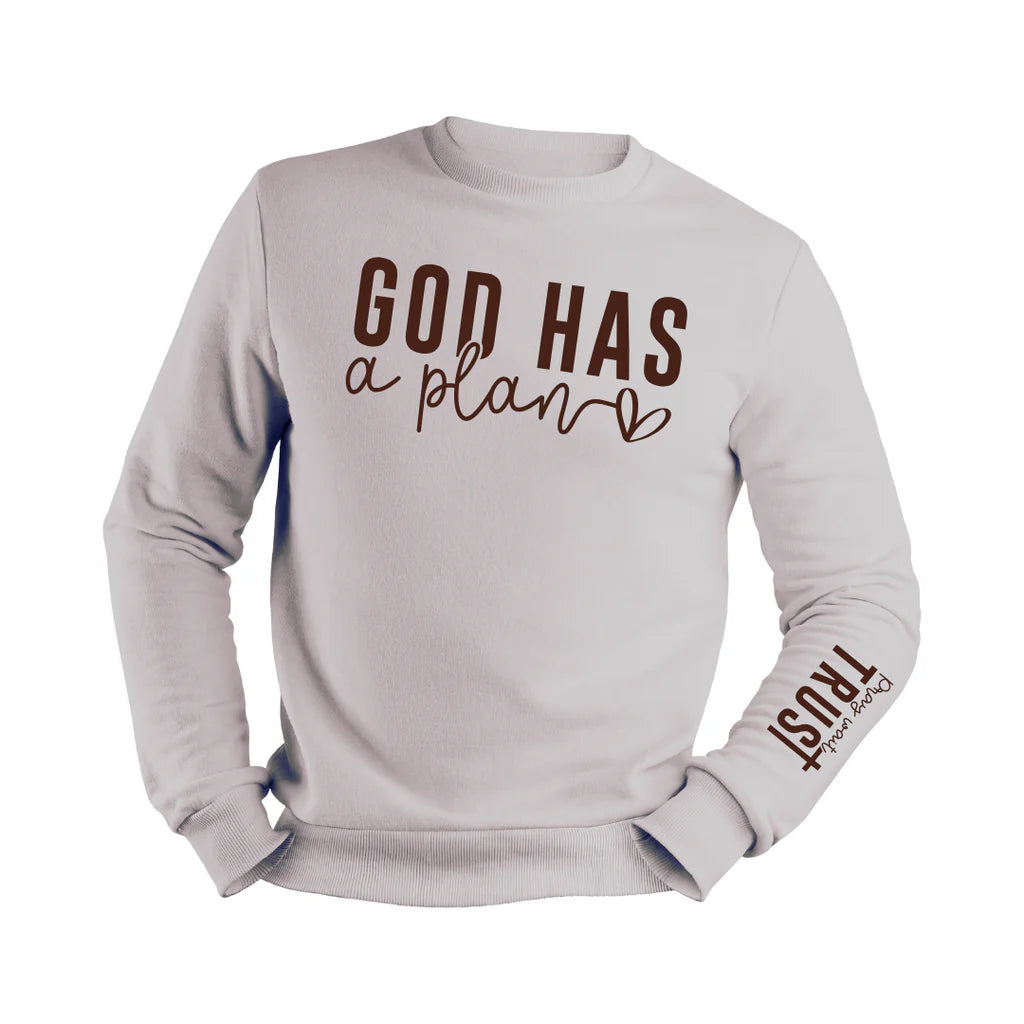 Gray cotton blend sweater with the phrase "God Has a Plan" in bold brown lettering on the chest and "Pray, Wait, Trust" on the sleeve, displayed against a light neutral background.